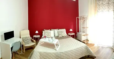 a bedroom with a bed and a red wall at Civico 20 in Palermo