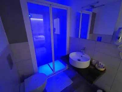 a bathroom with a sink and a shower with blue lights at La Casetta Di Rosina in Caccamo