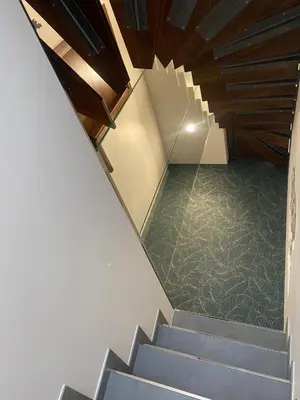 a staircase in a house with blue stairs and green carpet at La Casetta Di Rosina in Caccamo