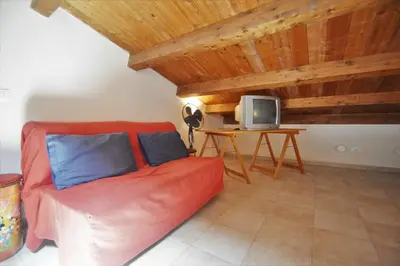 a living room with a red couch and a tv at Villa Mirage in Alcamo
