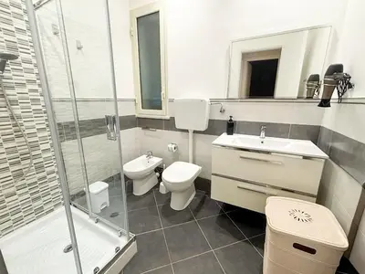 a bathroom with a toilet and a sink and a shower at Case Vacanze Mare Nostrum - Villas in front of the Beach with Pool in Campofelice di Roccella