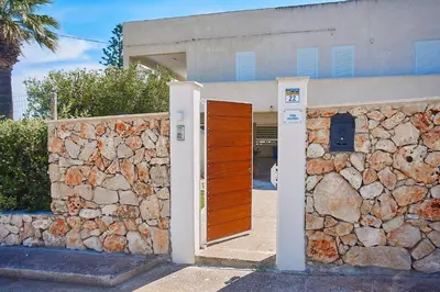 a building with a stone wall and a wooden door at Villa Ciuridda in Alcamo
