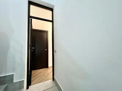 an empty hallway with a black door and a wooden floor at Ciuri di Sicilia in Capaci