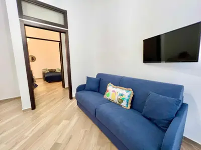 a blue couch in a living room with a flat screen tv at Ciuri di Sicilia in Capaci