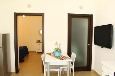 a dining room with a table with chairs and a tv at Ciuri di Sicilia in Capaci