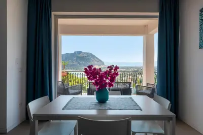 a dining room table with a vase of flowers on it at il sogno di Saffo in Palermo