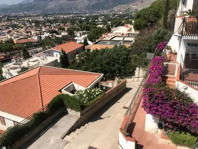 a view from the roof of a building with purple flowers at il sogno di Saffo in Palermo