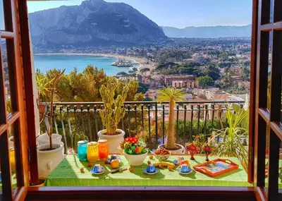 a table on a balcony with a view of the ocean at il sogno di Saffo in Palermo