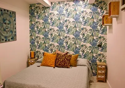 a bedroom with a bed with a blue and white wallpaper at Nido Verde Locazione turistica Palermo in Palermo