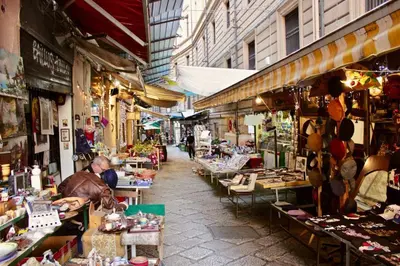 a market with a man sitting at tables in a street at Nido Verde Locazione turistica Palermo in Palermo