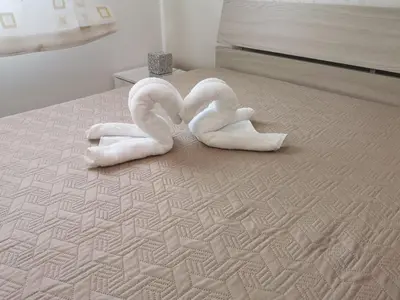 two towel swans are sitting on a bed at Casetta 
