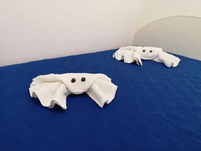 three stuffed elephants laying on a blue bed at Casetta 