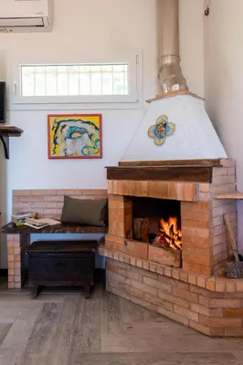 a brick oven with a fire in a room at La Casa nell'Oliveto a San Martino in Monreale