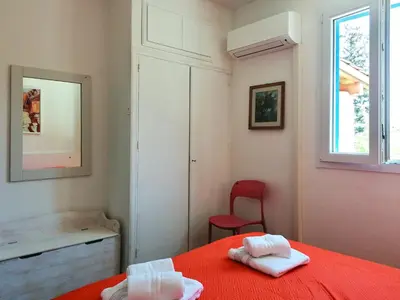 a bedroom with a red bed and a red chair at La Casa nell'Oliveto a San Martino in Monreale