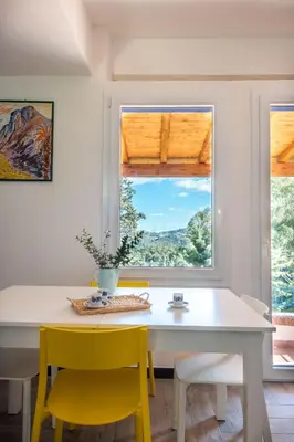 a dining room with a white table and yellow chairs at La Casa nell'Oliveto a San Martino in Monreale