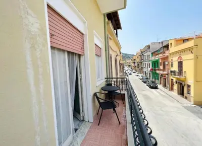 a balcony with a table and a chair on a street at Casa Kennedy in Capaci