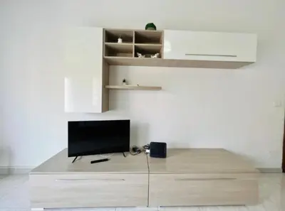 a tv sitting on top of a wooden stand in a room at Casa Kennedy in Capaci