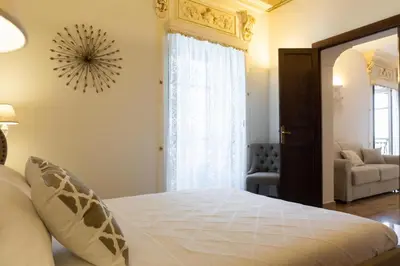 a bedroom with a bed and a living room at Appartamenti Porto Antico La Cala in Palermo