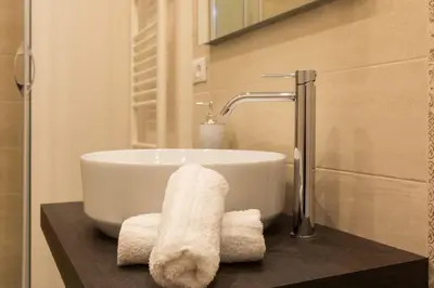 a bathroom with a sink and towels on a counter at Appartamenti Porto Antico La Cala in Palermo