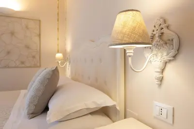 a bedroom with a white bed with a lamp at Appartamenti Porto Antico La Cala in Palermo