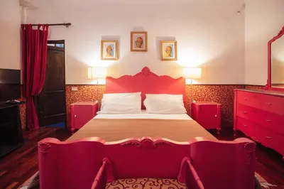 a bedroom with a large bed with red furniture at Cinematocasa Suite in Palermo