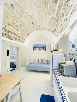 a kitchen and living room with a bed in the background at BLU MARE suite privata & apartment in Terrasini