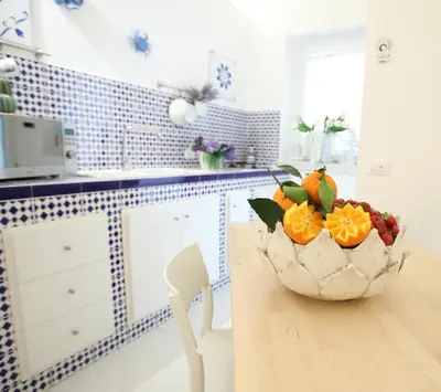 a bowl of fruit sitting on a table in a kitchen at BLU MARE suite privata & apartment in Terrasini
