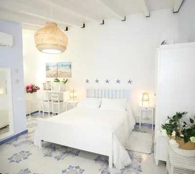 a white bedroom with a bed and a pendant light at BLU MARE suite privata & apartment in Terrasini