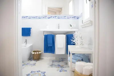 a bathroom with blue and white towels and a sink at BLU MARE suite privata & apartment in Terrasini