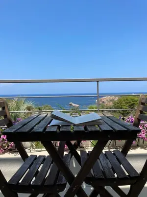 a wooden picnic table with a book on top of it at Cocciu d’amuri in Terrasini