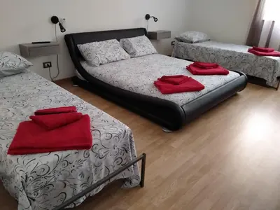 a room with two beds and a couch with red towels at Olivuzza Serena in Palermo