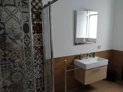 a bathroom with a shower with a sink and a mirror at Olivuzza Serena in Palermo