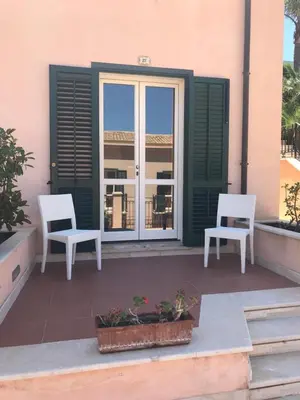 two white chairs sitting on a patio in front of a building at Castellammare Smart Rooms in Castellammare del Golfo