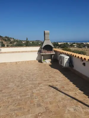 a patio with a fireplace on the side of a house at Appartamento a San Vito lo capo in San Vito lo Capo