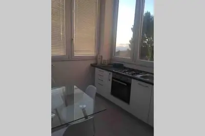 a kitchen with a stove and a sink and windows at Gibilrossa BeeHill in Misilmeri