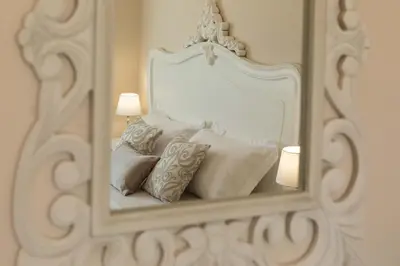 a mirror on a wall with a bed with pillows at Camera Vento Porto Antico La Cala in Palermo