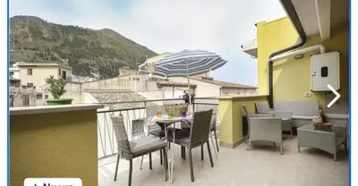 a balcony with a table and chairs and an umbrella at Appartamento francy in Castellammare del Golfo