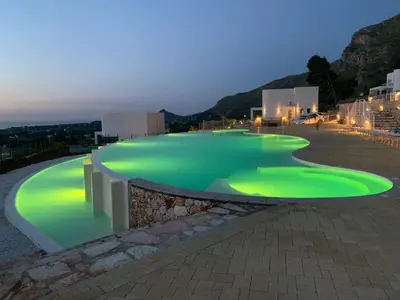 a swimming pool with green lighting on top of a building at Giardino degli Allori - Villa Flores in Castellammare del Golfo