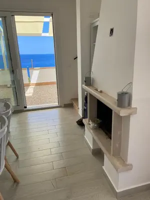 a living room with a fireplace and a view of the ocean at Villa Costanza in San Vito lo Capo