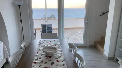 a dining room with a table and a view of the ocean at Villa Costanza in San Vito lo Capo