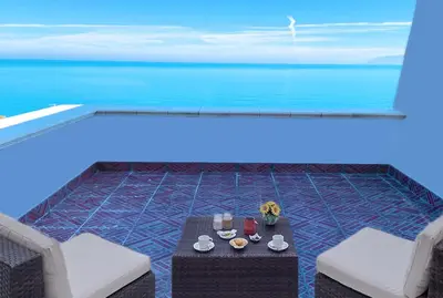 a table and two chairs with a view of the ocean at Villa Costanza in San Vito lo Capo