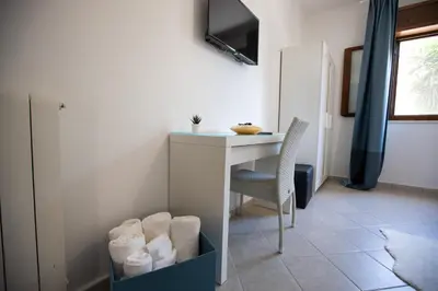 a room with a desk and a table and a chair at La casa di Nana’ locazione turistica in Palermo
