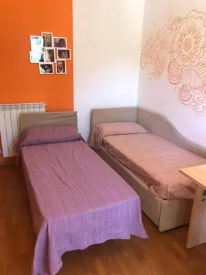 two beds in a room with pink sheets at Villa Tiziana in Monreale