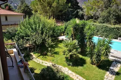a garden with palm trees and a swimming pool at Villa Tiziana in Monreale