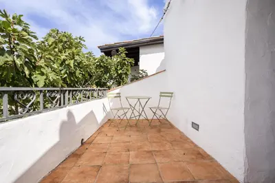 a balcony with two chairs and a table on it at Villa a 300 Mt. dal Mare (Magaggiari) con campo da tennis in Cinisi