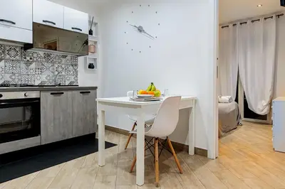 a kitchen with a table and a white table and chairs at Little House ai Tartari in Palermo