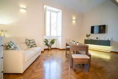 a living room with a white couch and a table at Suite Cathedral Palermo in Palermo