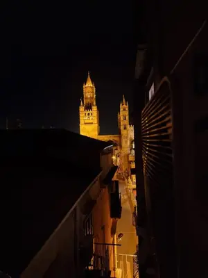 a lit up building with a tower at night at Suite Cathedral Palermo in Palermo