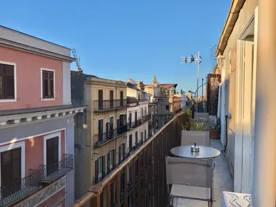 a balcony with a table and chairs on a city street at SUITE 4 CANTI in Palermo