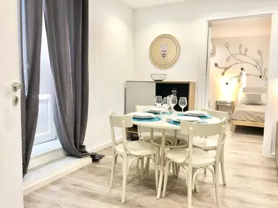 a dining room with a white table and chairs at SUITE 4 CANTI in Palermo